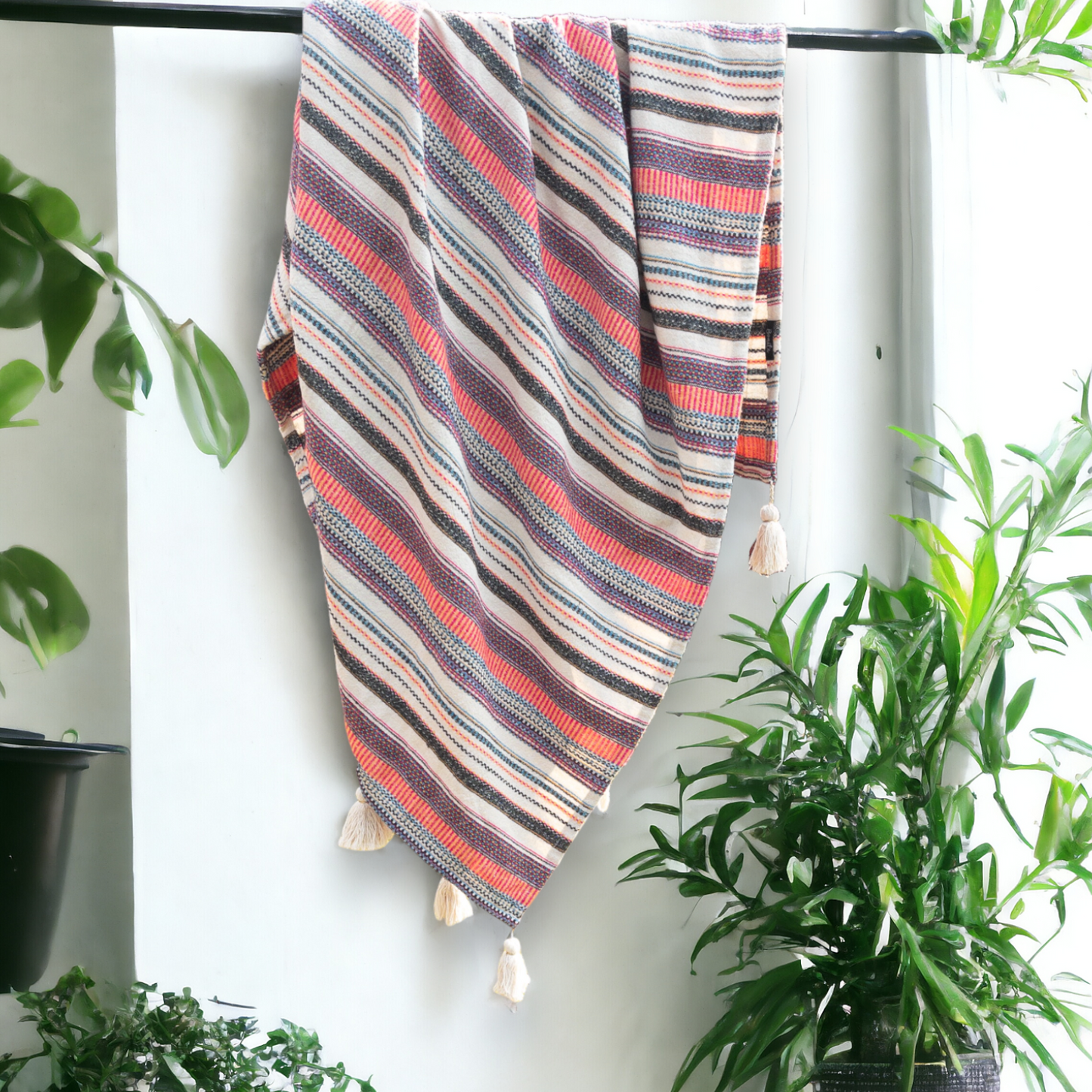 a multi color sofa throw hanging from a rod