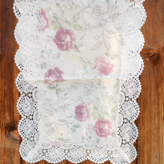 Formal lace table runner with floral work, placed on a dining table