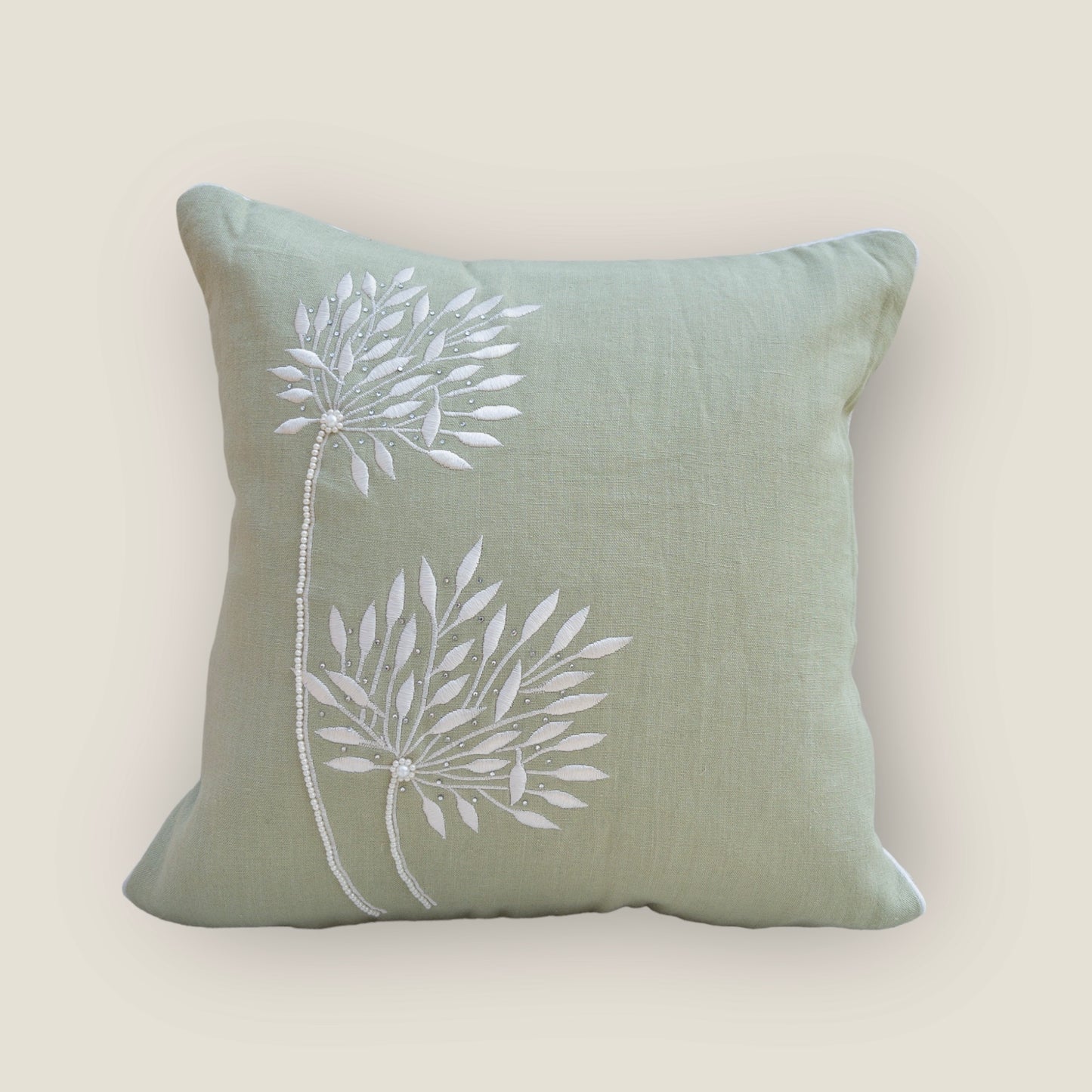mint green cushion cover with beautiful embroidery, placed on a chair