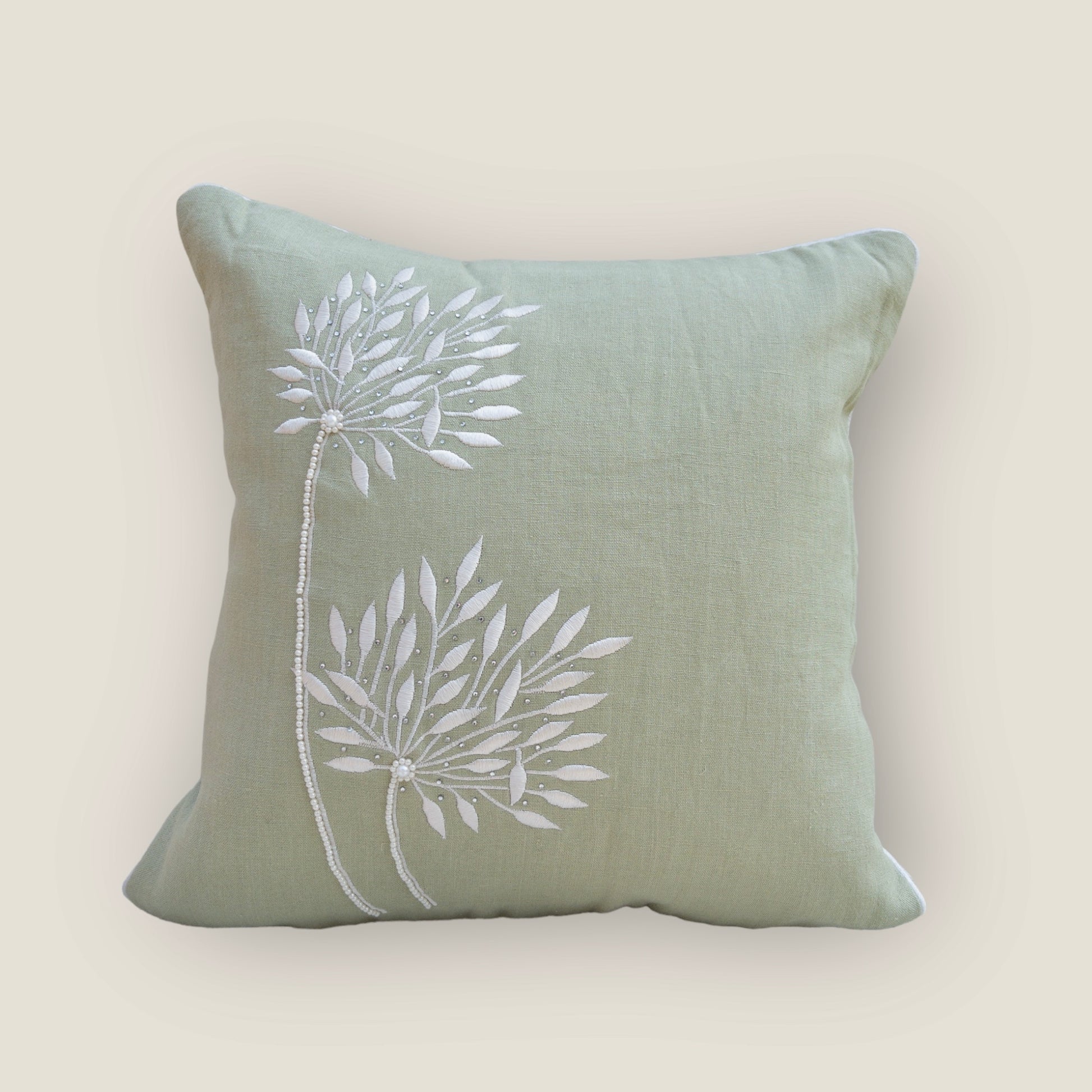 mint green cushion cover with beautiful embroidery, placed on a chair