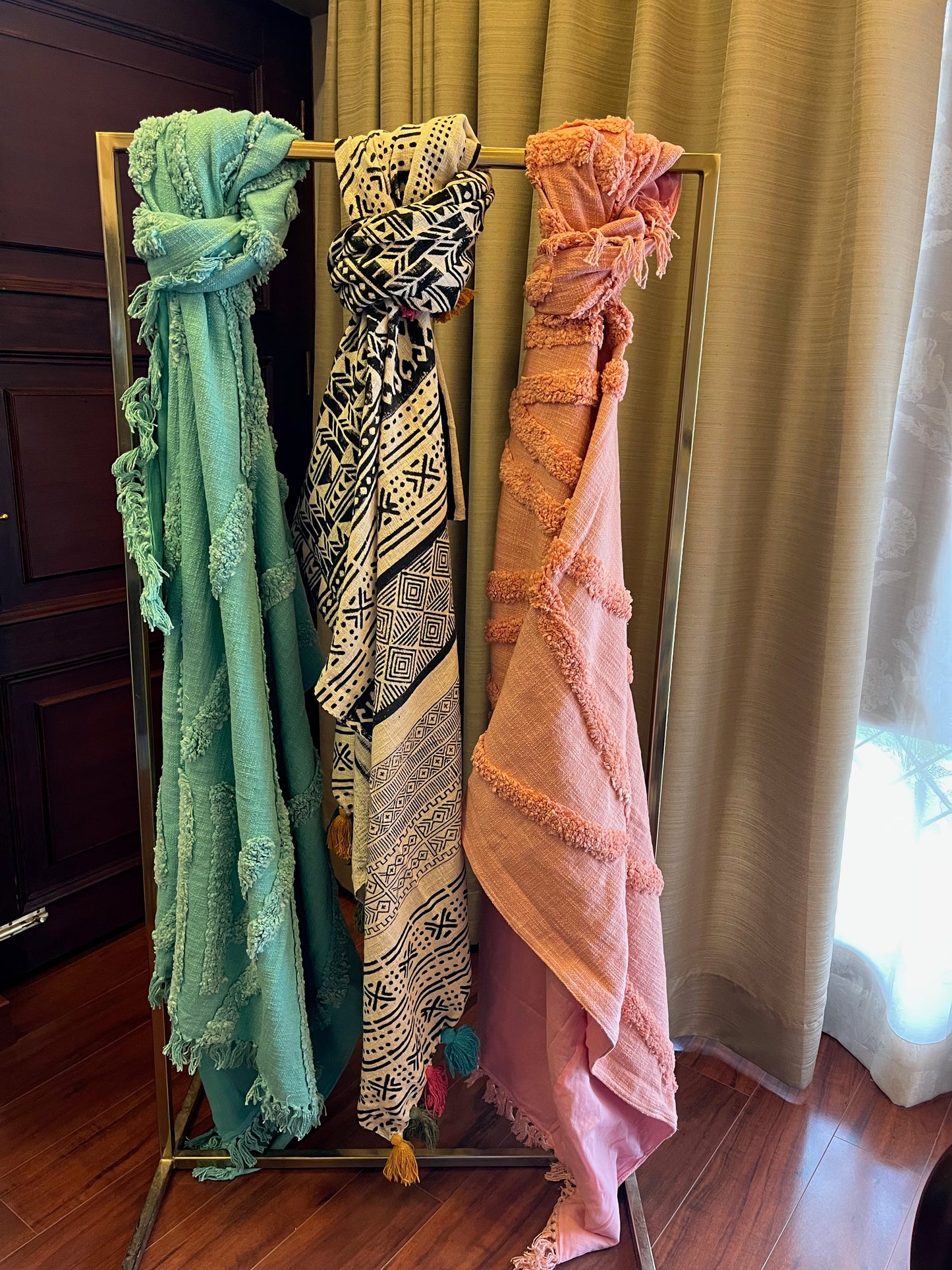 Three throws tied to a stand in a living room