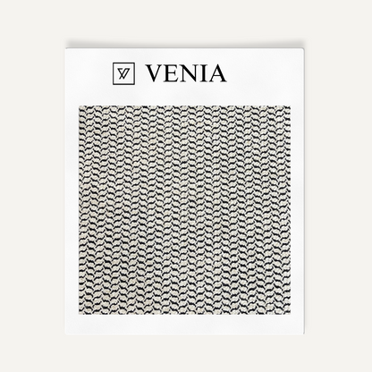 Textile sample with 'VENIA' branding and a black and white pattern on a white background