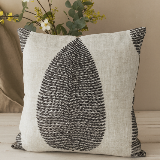 Decorative pillow with leaf pattern on a neutral background
