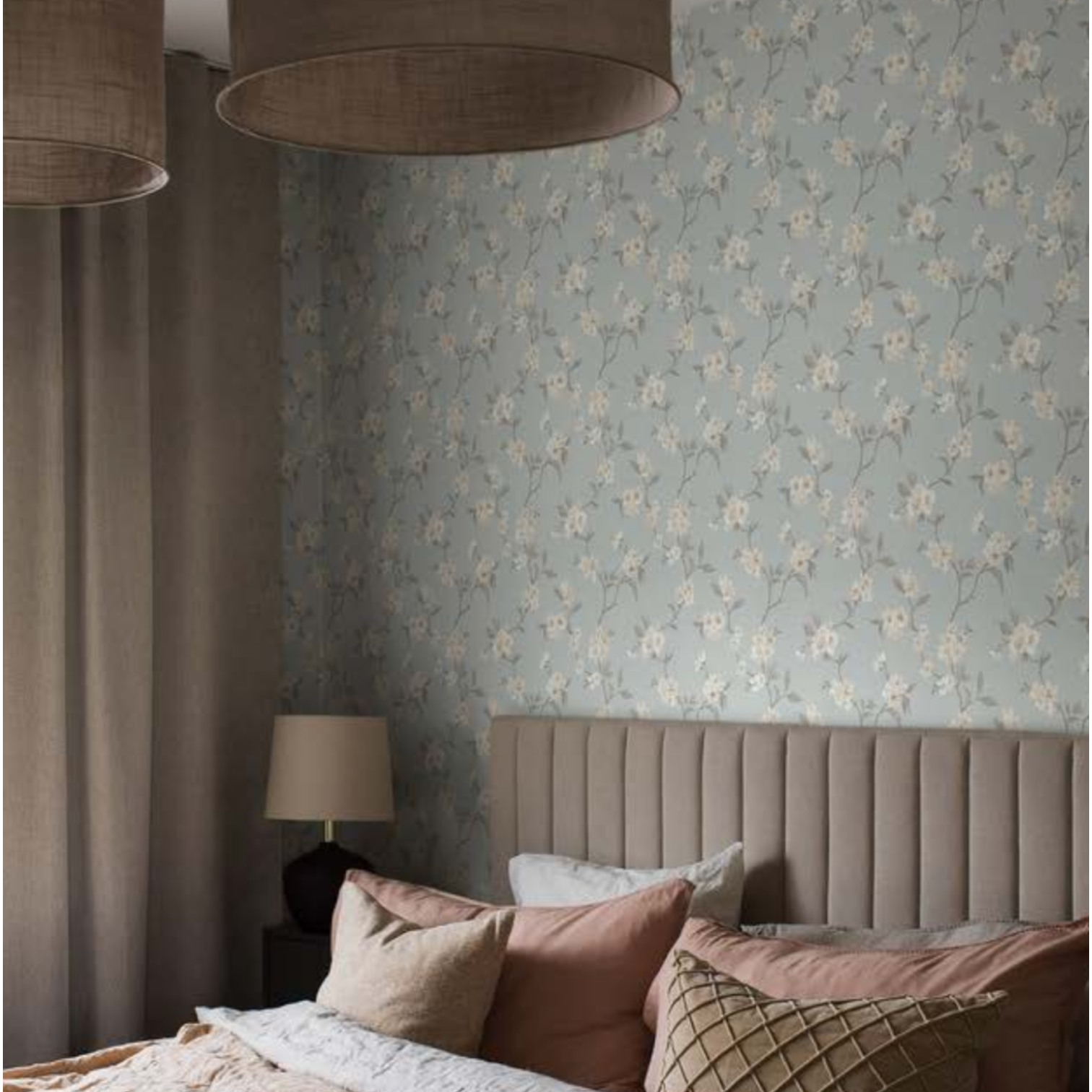 a bed in a a bedroom  where the wall is adorned with a blue floral wallpaper
