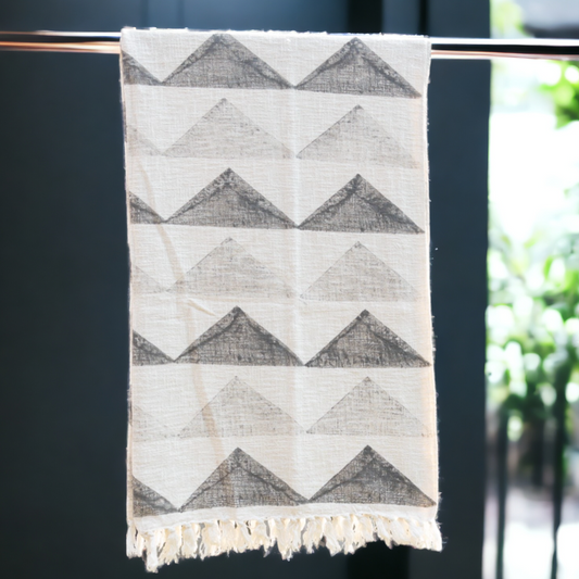 a grey and white sofa throw hanging from a rod