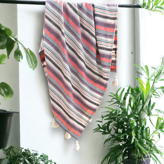 a multi color sofa throw hanging from a rod