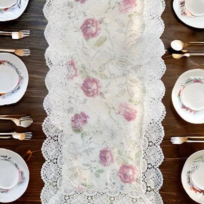 Formal lace table runner with floral work, placed on a dining table