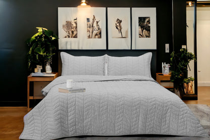 A bedcover set, spread on a bed