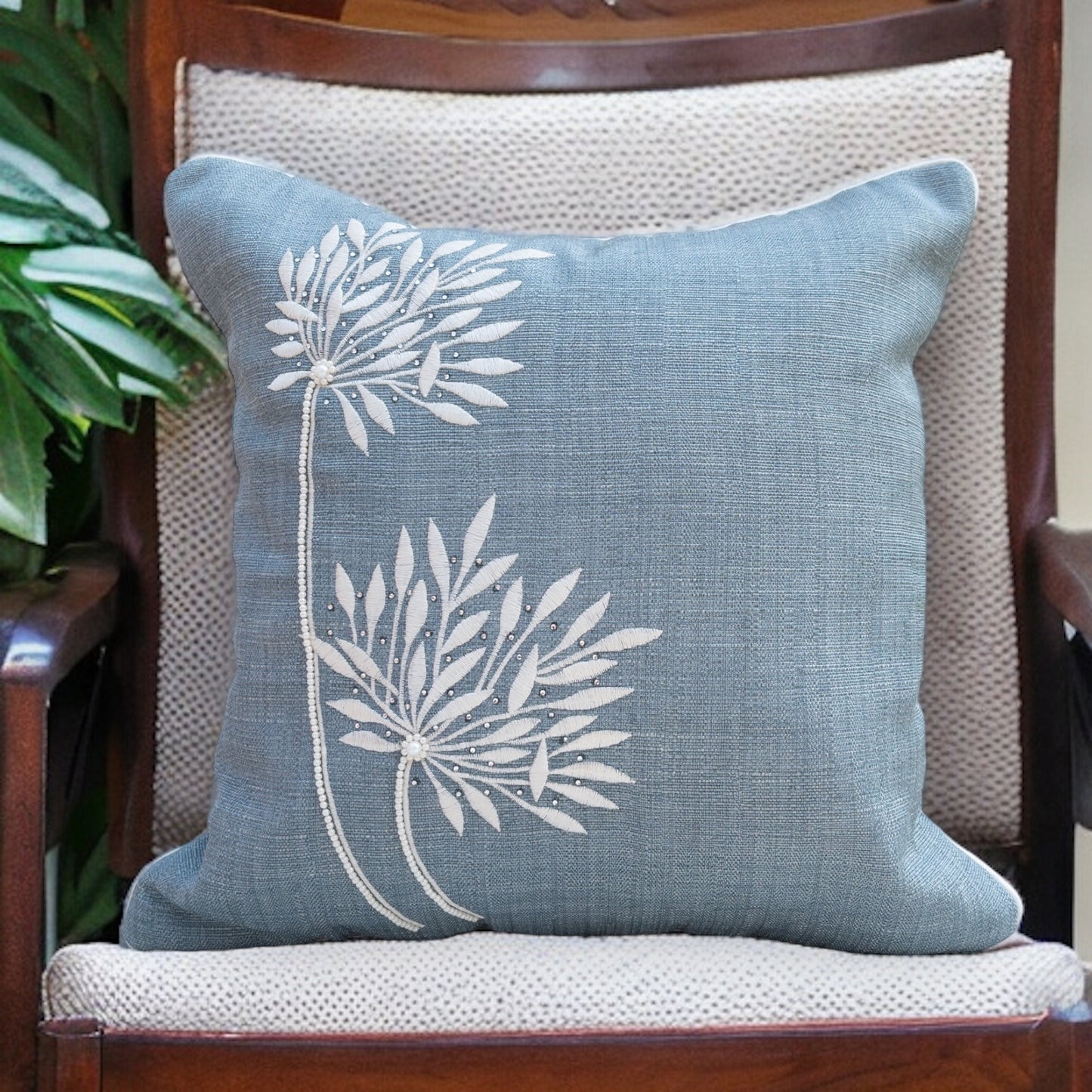 blue cushion cover with beautiful embroidery, placed on a chair 