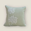 mint green cushion cover with beautiful embroidery, placed on a chair 