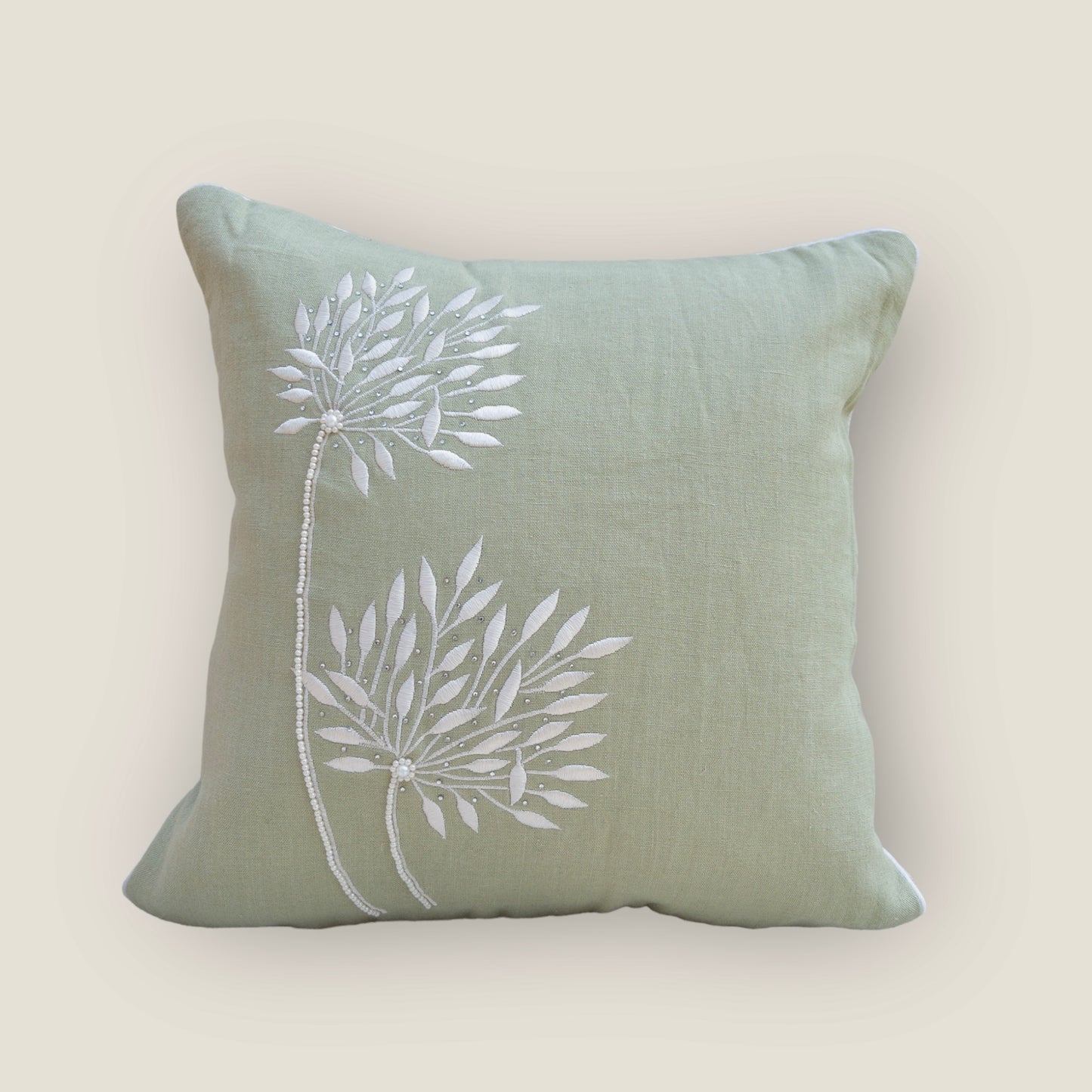 mint green cushion cover with beautiful embroidery, placed on a chair 