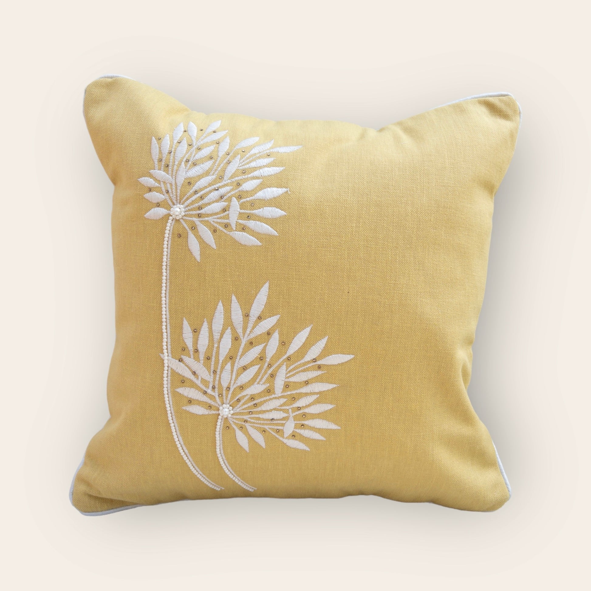 yellow cushion cover with beautiful embroidery, placed on a chair 