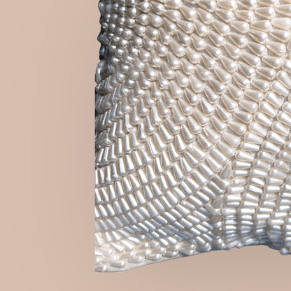 close up of luxurious cushion cover with white pearls, ideal for living rooms