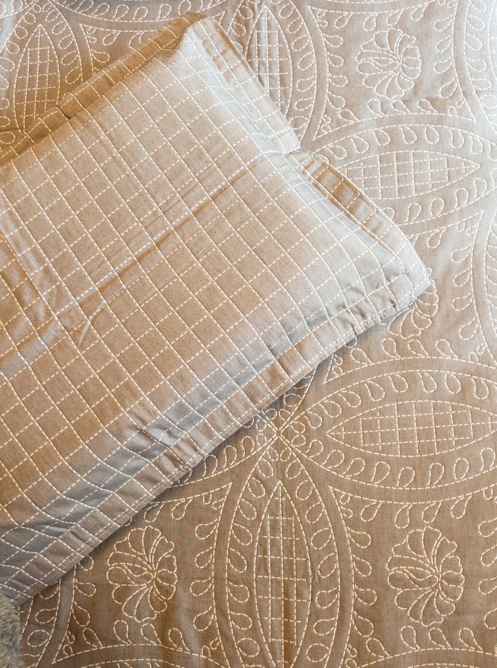 A bedcover set, spread on a bed