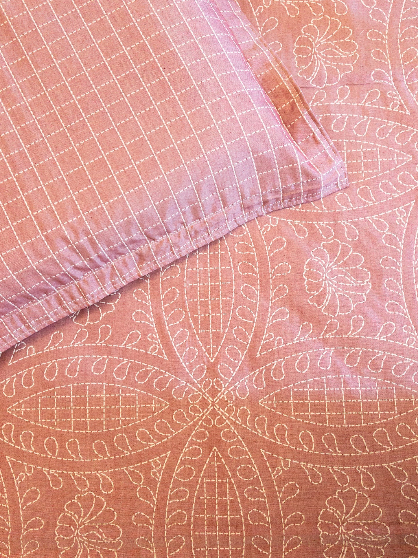 A bedcover set, spread on a bed