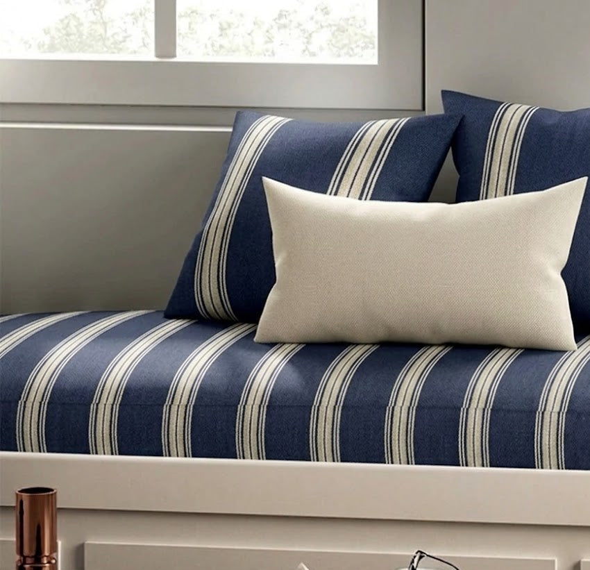 Navy and white striped sofa with decorative pillows in a living room setting
