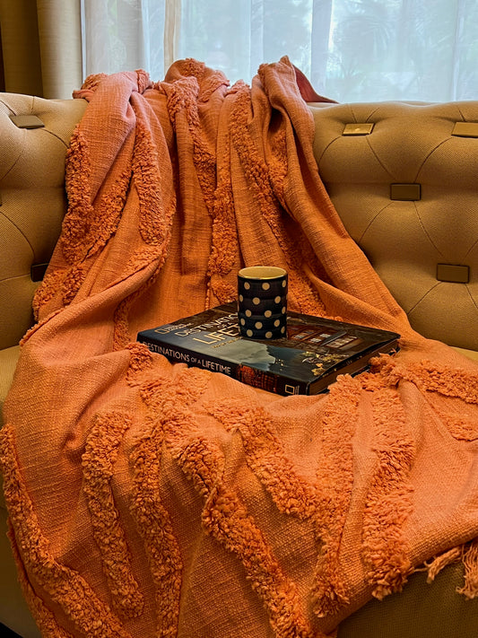 a pink tufted throw styled on a sofa