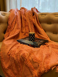 a pink tufted throw styled on a sofa