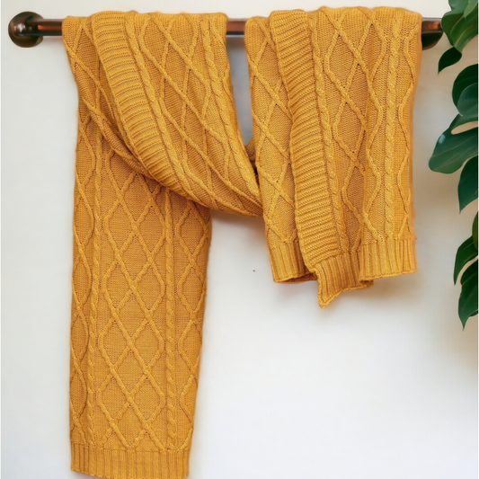 yellow knitted sofa throw hanging by a rod
